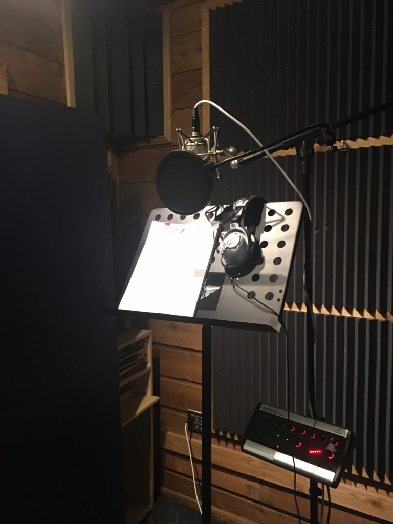 Music stand with voiceover script and recording mic in a sound studio